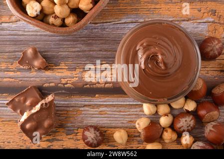 Crema di cacao con nocciole e cioccolato intorno al tavolo. Vista dall'alto. Foto Stock