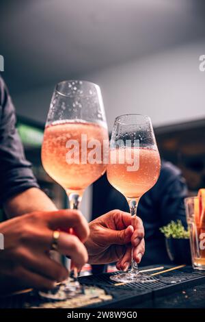 Bicchiere di cocktail Aperol spritz ghiacciato servito in un bicchiere di vino, posto su un bancone del bar Foto Stock