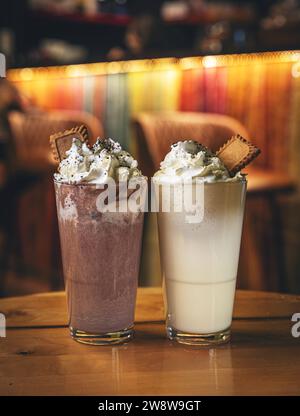 Frullate con panna montata con biscotti e cacao in polvere Foto Stock