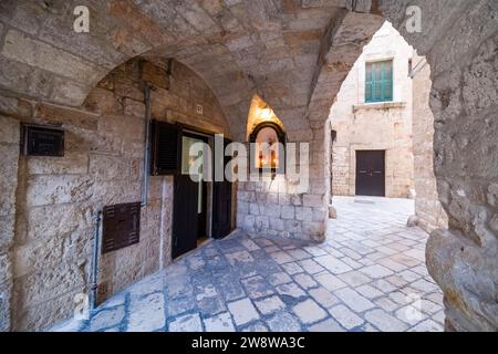 Scena di strada con un piccolo cortile tra case, archi e volte. Foto Stock