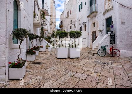 Scena di strada con una piccola piazza tra case, balconi, scalinate e piante verdi in vaso. Foto Stock