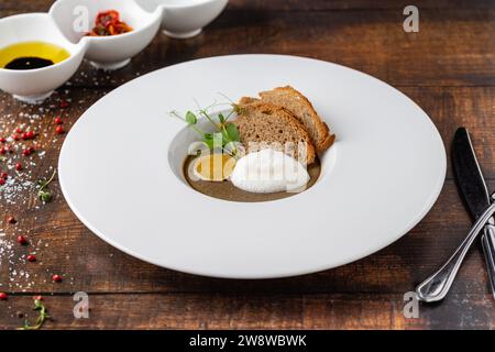 Crostini fegatini su piatto di porcellana bianca su tavolo in legno Foto Stock