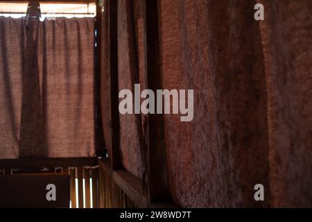 Tende sulla veranda. Veranda in legno. Interno con grandi finestre. Tessuto marrone. Foto Stock