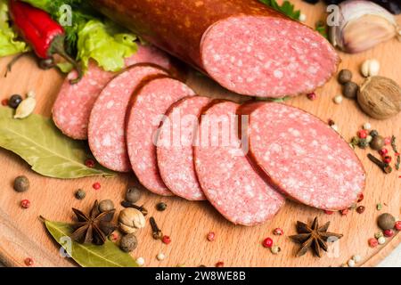 Vista dall'alto della salsiccia affumicata con condimenti, verdure e fette di pane di segale Foto Stock