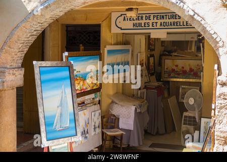 Galleria d'arte che vende dipinti e quadri incorniciati ai turisti da un negozio di arcate sulla CR Masséna, affacciato sul mercato coperto "le Marche provenzali" nel centro storico di Antibes, Côte d'Azur, Costa Azzurra, Francia. (135) Foto Stock
