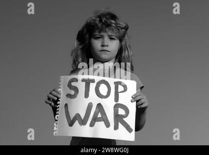 Il bambino porta un cartello Stop war. Ritratto il ragazzino chiama a fermare la guerra, alza la bandiera con l'iscrizione fermare la guerra. Bambino in una protesta con ucraino Foto Stock