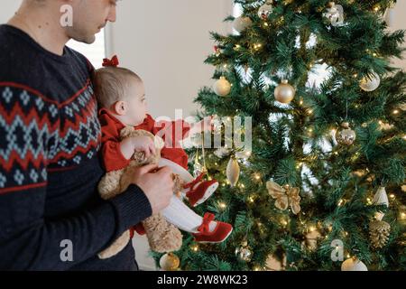 Papà e bambina condividono il divertimento dell'albero di natale Foto Stock