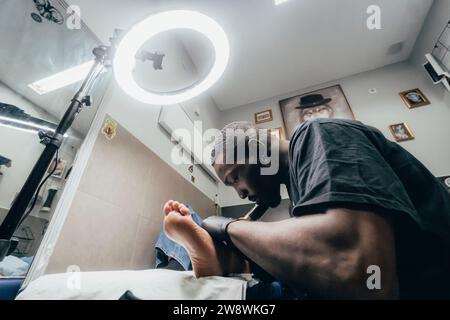 uomo che tatua con luce flexo Foto Stock