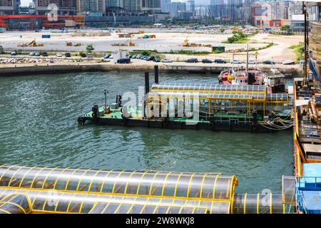 Attracchi adiacenti al Terminal dei traghetti China Ferry, Hong Kong, e lavori di costruzione della stazione di Hong Kong West Kowloon. Foto Stock