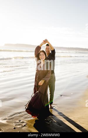 Coppia asiatica che balla sulla spiaggia al tramonto a San Diego Foto Stock