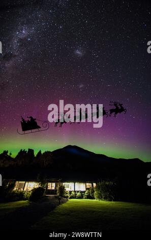 Babbo Natale attraversa il cielo notturno sul parco nazionale di Fiordland con l'aurora Australis e la via Lattea, South Island, nuova Zelanda. Foto Stock