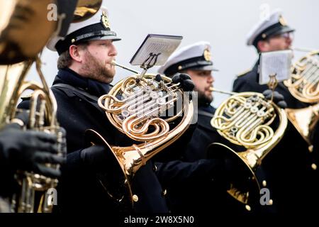 Wilhelmshaven, Germania. 22 dicembre 2023. Il Wilhelmshaven Naval Music Corps suona su un muro di banchina mentre la fregata "Hessen" entra nel porto presso la base navale. Con circa 230 militari e donne a bordo, la fregata tornò al suo porto di origine poco prima di Natale. Negli ultimi cinque mesi, la nave ha partecipato a tre grandi manovre e a molte esercitazioni nel Mare del Nord, nel Mar Baltico e nell'Atlantico settentrionale. Credito: Hauke-Christian Dittrich/dpa/Alamy Live News Foto Stock