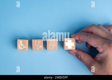 Disposizione di cubi di legno a forma di icona medica sanitaria, simboleggia l'assicurazione per la tua salute e il concetto di segno più. Foto Stock