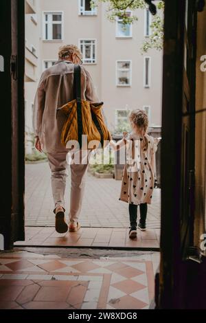 Donna anziana che cammina con la nipote vista attraverso la porta Foto Stock