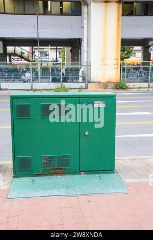 Armadio di controllo elettrico verde esterno montato su una base in cemento sul lato della strada in città. Foto Stock