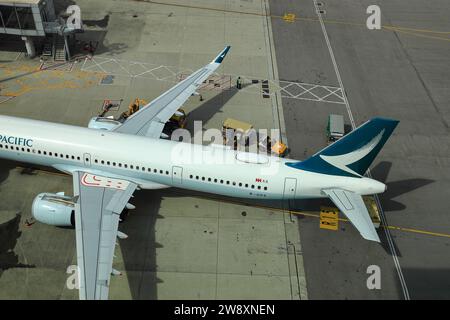 Striscia bianca e freccia rossa sopra l'ala dell'aeroplano cathay Pacific Airway che indica la via di un'emergenza sopra l'uscita dell'ala esterna di un aereo. Foto Stock