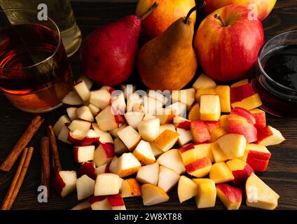 Pere Bosc tritate, pere Anjou rosse e mele croccanti al miele: Frutta tritata con pere intere e mele, bastoncini di cannella, bourbon e sciroppo d'acero Foto Stock