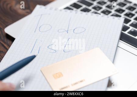 Immagine di un notebook e di una carta di credito appoggiati su un computer portatile. Concetto di pianificazione dello shopping. Pianificazione del budget familiare. Supporti misti Foto Stock