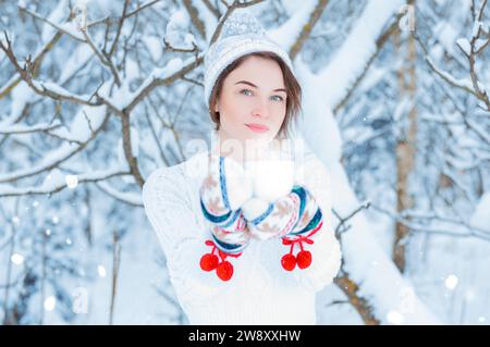 Ritratto di una bella donna che tiene in mano una tazza di tè. Concetto di Natale, feste invernali, passeggiate nei boschi, vacanze. Supporti misti Foto Stock