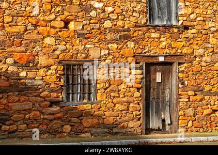 Case, finestre e facciate costruite con pietra calcarea rossa tipica della regione di la Maraguatería a Castilla y León, Spagna Foto Stock