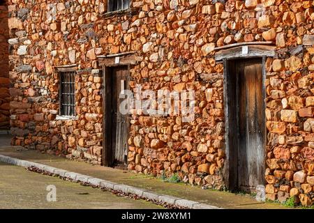 Case, finestre e facciate costruite con pietra calcarea rossa tipica della regione di la Maraguatería a Castilla y León, Spagna Foto Stock