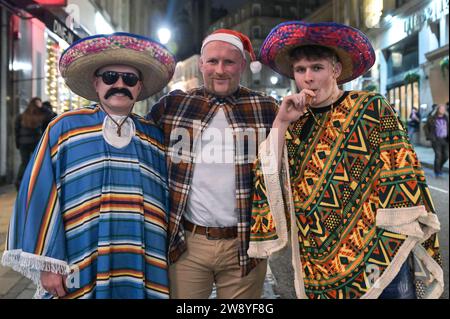 Birmingham 22 dicembre 2023 - i rivenditori sono andati a Birmingham il Mad Friday, che prende anche il nome di Black Eye Friday. I gruppi di lavoro erano in pieno svolgimento mentre le aziende chiudevano per le vacanze di Natale. Si è visto molto passeggiare per il centro della città con un enorme bicchiere di birra da mercato tedesco e molti indossavano cappelli di Babbo Natale. Un gruppo di 3 compagni di lavoro si è recato in un ristorante messicano per le loro attività e due hanno indossato abiti messicani con il loro collega che si è attaccato a un tradizionale cappello di Babbo Natale. Alcuni amici sono stati anche avvistati su Broad Street, con un soffio alla fermata del tram con uno che tiene l'altro in un blocco. Un altro gr Foto Stock