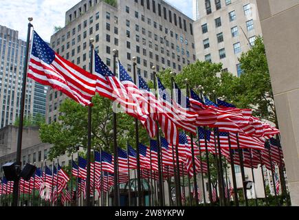 New York City, NY, USA - 3 luglio 2023: Le bandiere americane sui pali sventolano nel vento. Rockfeller Center, New York City Foto Stock