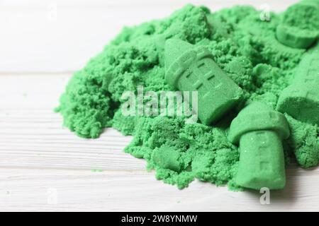 Figure del castello fatte di verde sabbia cinetica su un tavolo bianco, primo piano Foto Stock