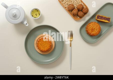 Il piccolo tavolo da festa del Mid-Autumn Festival è decorato con deliziose torte lunari, set da tè e noci. Scena pubblicitaria di torte lunari - un cak tradizionale Foto Stock