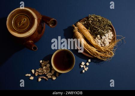 Su uno sfondo blu scuro, le erbe folcloristiche sono esposte su piatti di legno decorati con pentole e tazze medicinali. Scena pubblicitaria per le pubbliche relazioni sanitarie Foto Stock