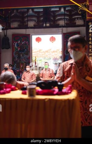 Bandung, Indonesia - 8 gennaio 2022: Il visitatore che prega insieme ai monaci di fronte alle offerte al dio al tempio del Buddha Foto Stock