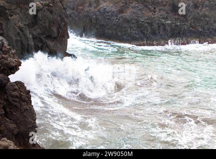 Vista panoramica di Los Hervideros. Costa sudoccidentale, aspra costa vulcanica, surf forte, grotte marine, colline di lava rossa. Lanzarote, Isole Canarie, Spagna Foto Stock