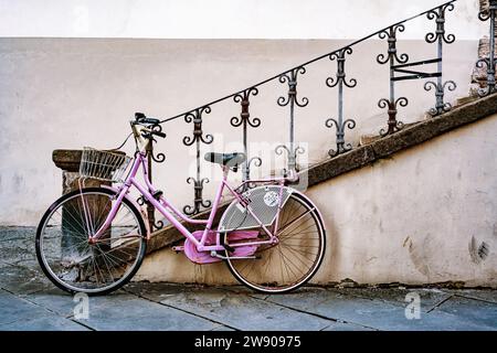 Bicicletta d'epoca con cassa di legno, bicicletta appoggiata su un muro di strada italiana a Lucca, Italia Foto Stock