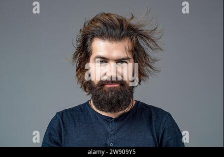 Ritratto di un uomo elegante. Barba perfetta. Uomo barbuto, acconciatura elegante, barba isolata su sfondo grigio. Taglio di capelli da uomo in barbiere. Uomo sorridente Foto Stock