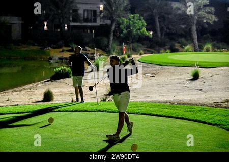 Abu Dhabi, Emirati Arabi Uniti. 7 dicembre 2023. Un golfista dilettante fa un tiro. Yas Acres and Country Club, Night Golf, Abu Dhabi, Emirati Arabi Uniti. Il campo da golf a 9 buche progettato da Fry/Straka, di 3700 metri (3,383 metri), è situato nella comunità Yas nel centro di Abu Dhabi, funge da centro culturale e sociale per la gente del posto e gli ex paters. Credito: SOPA Images Limited/Alamy Live News Foto Stock