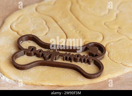 Preparare dolci fatti in casa per cani sani. Impastare con le taglierine per biscotti. Foto Stock