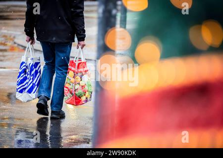 Berlino, Germania. 23 dicembre 2023. Passeggia con le borse per lo shopping lungo la strada dello shopping Schloßstraße a Steglitz. Credito: Christoph Soeder/dpa/Alamy Live News Foto Stock