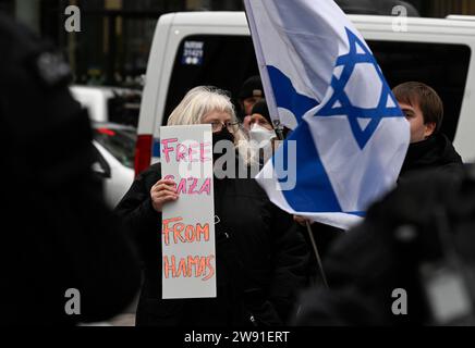 Colonia, Germania. 23 dicembre 2023. I manifestanti pro-israeliani dell'iniziativa "Clear Edge Against the Demonization of Israel” osteggiano i manifestanti pro-palestinesi con una bandiera israeliana e un poster con la scritta "Gaza libera da Hamas”. Crediti: Roberto Pfeil/dpa/Alamy Live News Foto Stock