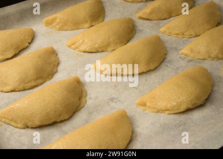 Un vassoio da forno con dolci patate crude (pastissets) che aspetta di essere cotto. Tipico dolce natalizio in Spagna Foto Stock