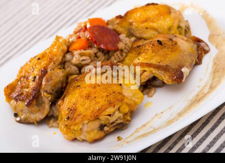 Cosce di pollo al forno con porridge di orzo Foto Stock