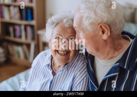 Donna anziana sorridente con un uomo a casa Foto Stock