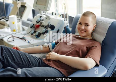 Donna sorridente sdraiata sul divano a donare sangue Foto Stock