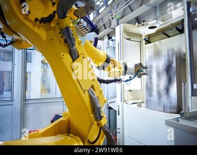 Braccio robotico giallo in fabbrica Foto Stock