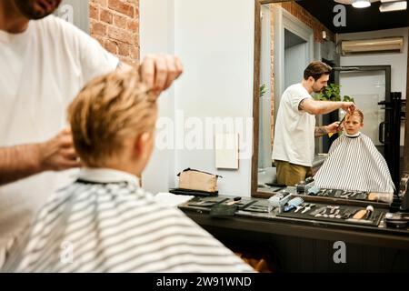 Barbiere che taglia i capelli del cliente davanti allo specchio del salone Foto Stock