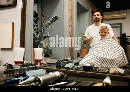 Barbiere prepara il cliente per il taglio dei capelli Foto Stock