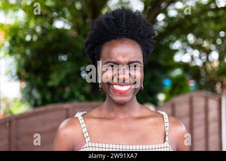 Felice giovane donna con l'acconciatura afro nel parco Foto Stock