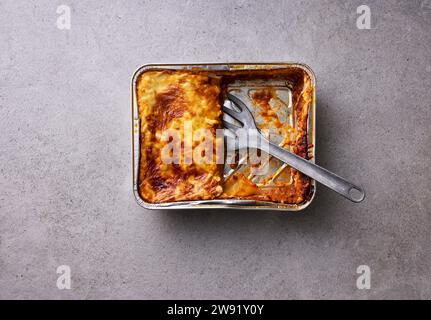 Lasagne cotte a metà in teglia da forno Foto Stock