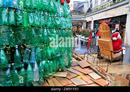 Bordeaux, Francia. 23 dicembre 2023. Ecologia e albero di Natale 100% eco-responsabile. Questo albero di Natale creato con 3000 bottiglie di plastica recuperate aumenta la consapevolezza del consumo eccessivo di plastica che inquina gli oceani e il pianeta. I visitatori sono incoraggiati ad adottare comportamenti più ecologici nella loro vita quotidiana per ridurre o evitare questo inquinamento. Ogni minuto quasi un milione di bottiglie di plastica vengono vendute in tutto il mondo. Foto di Hugo Martin/Alamy Live News. Foto Stock