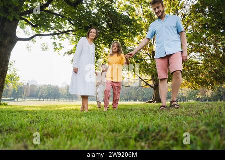 Padre e madre giocano con i bambini al parco Foto Stock