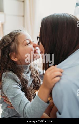 Una madre amorevole che strofina il naso con la figlia a casa Foto Stock